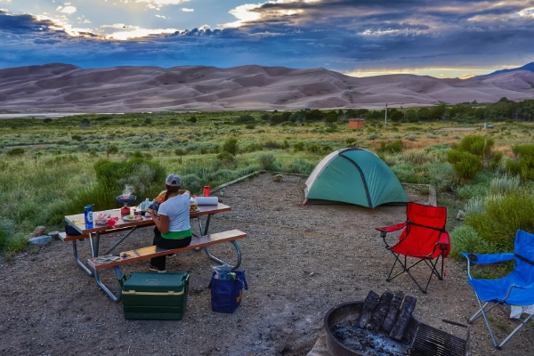 A tent set up at Piñon Flats Campground with the dunes in the background