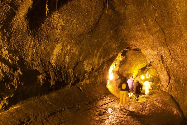 A person walking through the illuminated Thurston Lava Tube