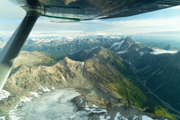 A small plane flying over the volcanic landscapes of Katmai