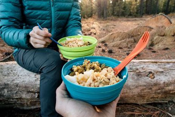 A person preparing a meal at a remote backcountry campsite
