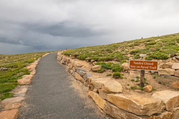 A hiking trail across a vast, otherworldly alpine tundra landscape